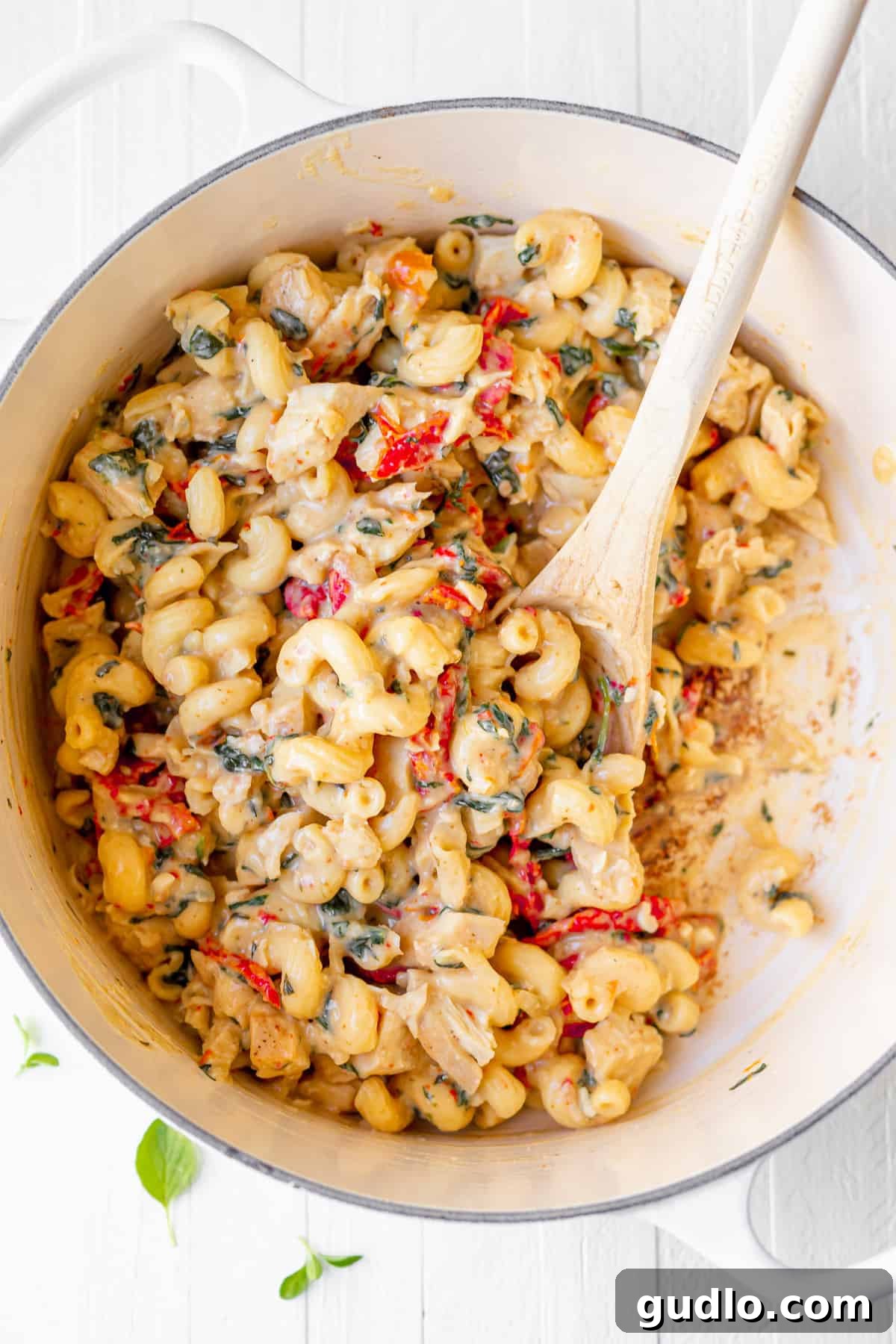 This Tuscan Chicken Mac and Cheese is comfort food, but with an elegant twist! The delicious Tuscan flavors and incredibly creamy, cheesy goodness will undoubtedly make this dish a new family favorite in your home, too, for unforgettable meals. A large pot filled with all the delicious Tuscan chicken mac and cheese ingredients perfectly mixed together and steaming, ready to be served hot.