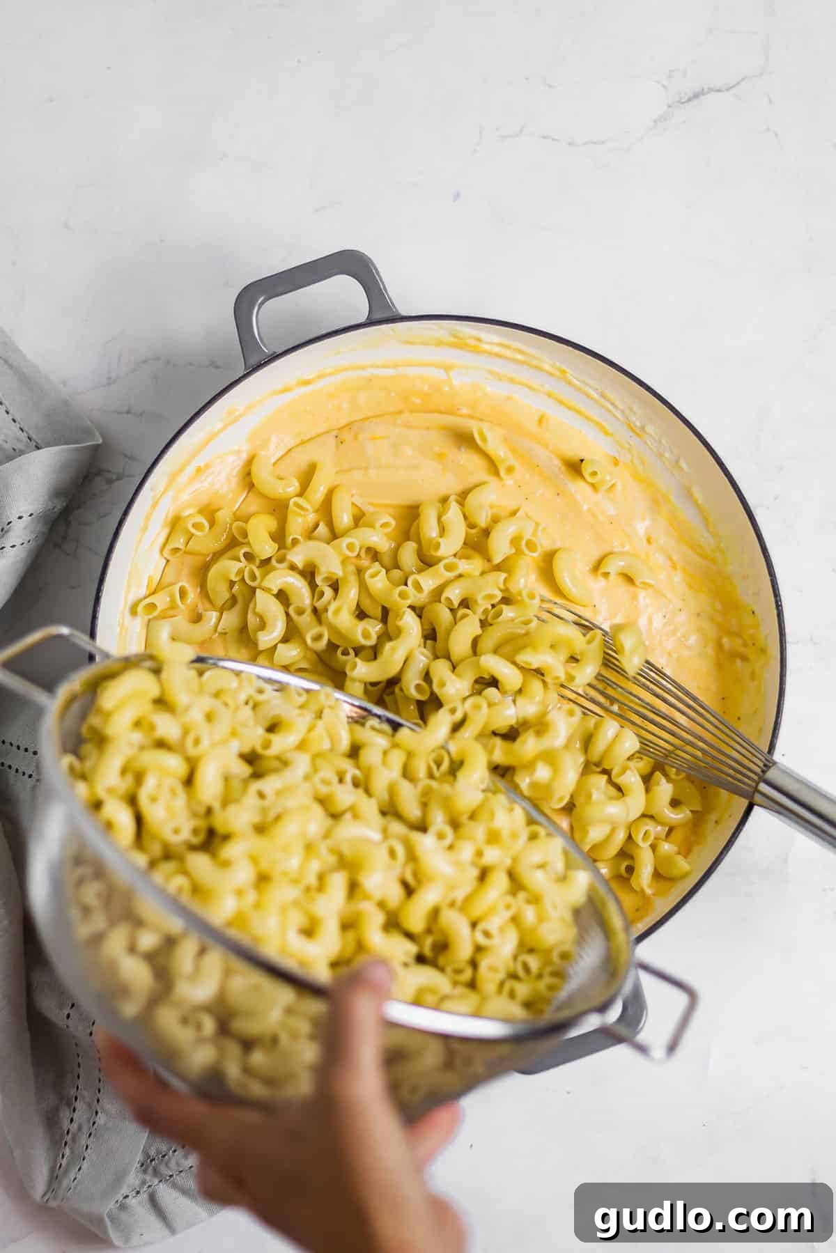 Say hello to the BEST mac and cheese on the internet! This Classic Mac and Cheese recipe is cheesy, creamy and made completely on the stovetop. Enjoy! Cooked macaroni noodles being added to the rich, creamy mac and cheese sauce and gently stirred until every noodle is coated.