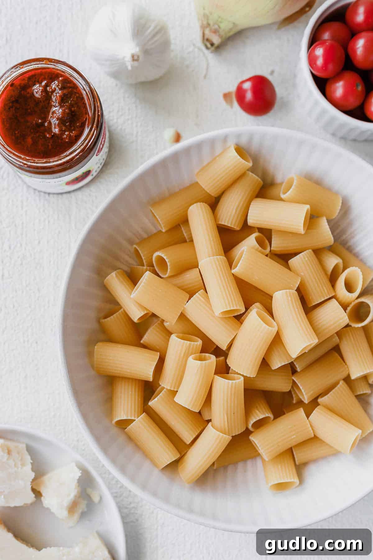 Close-up of sun dried tomato pasta on a white plate, ready to be served.
