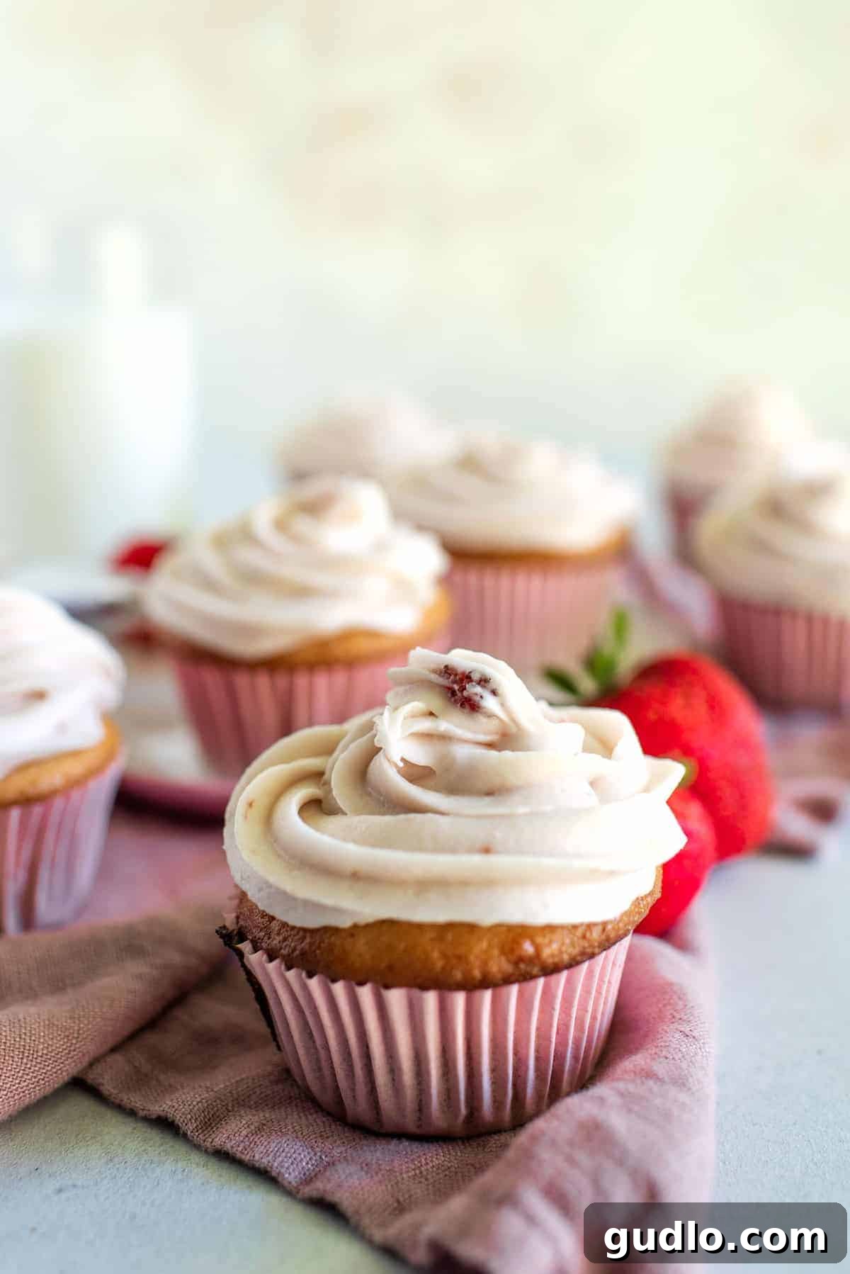 Perfect Strawberry Cream Cheese Frosting on a cupcake. Delicious strawberry cream cheese frosted cupcake with a fresh strawberry on top.