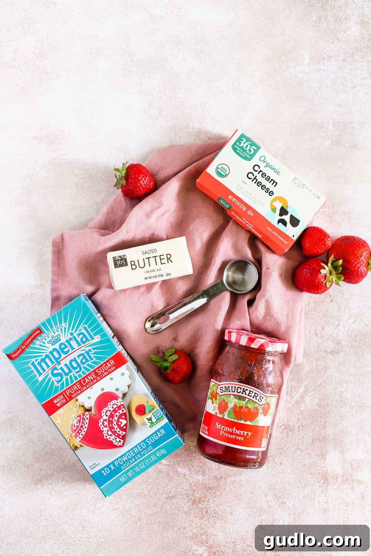 Strawberry Cream Cheese Frosting ingredients. The essential ingredients for strawberry cream cheese frosting laid out: cream cheese, butter, strawberry preserves, and powdered sugar.