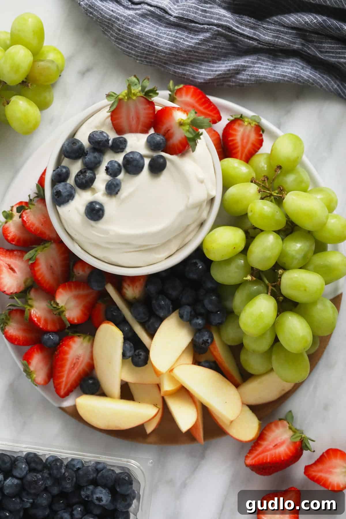 cream cheese fruit dip surrounded by fresh fruit on a plate.