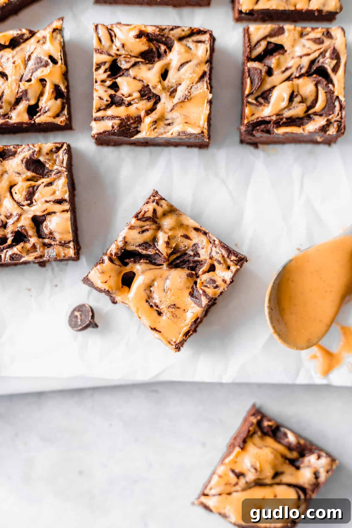 Peanut Butter Chocolate Cheesecake Fudge 2 Creamy peanut butter swirl chocolate cream cheese fudge artfully arranged on wax paper, ready to be enjoyed.