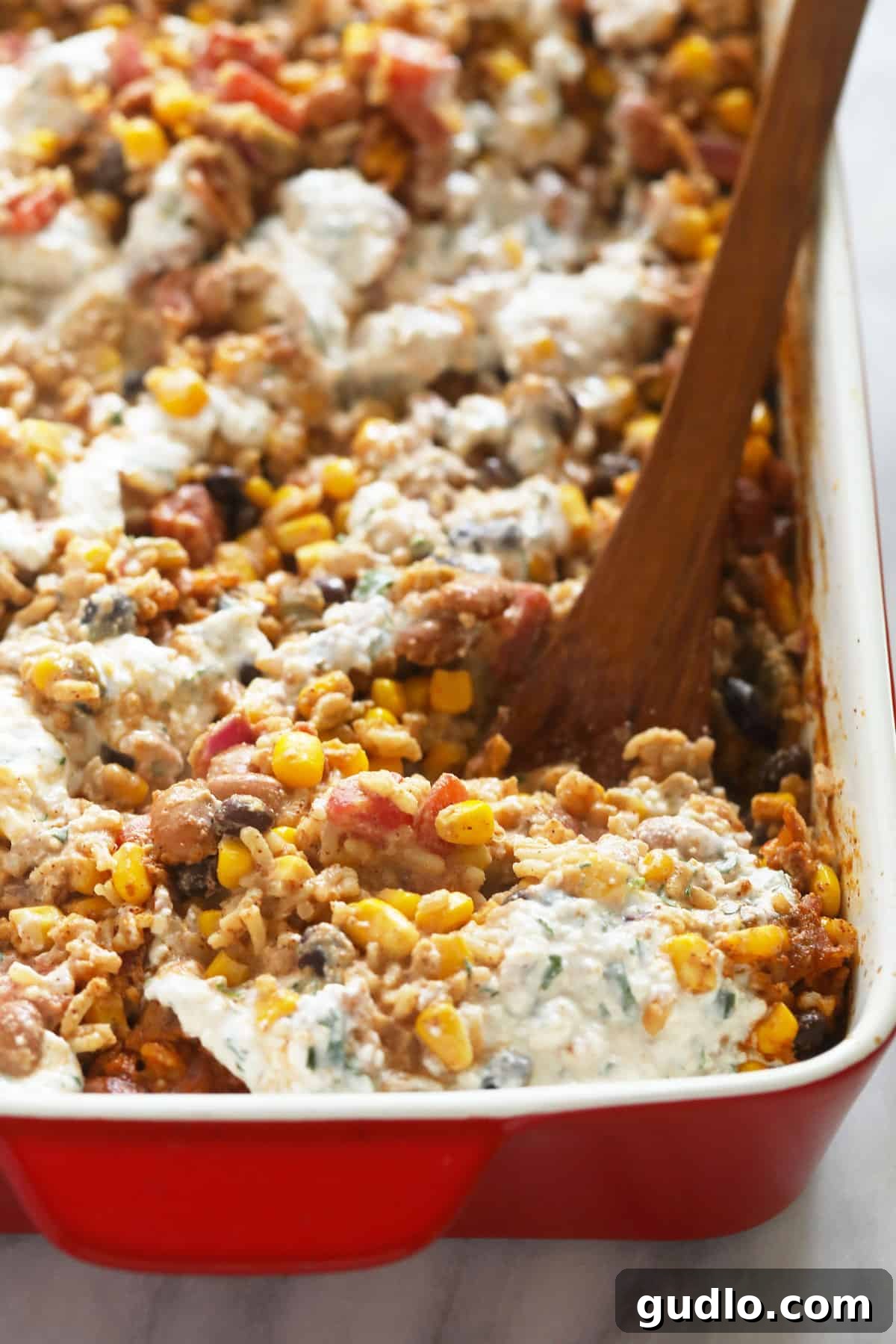The perfect topping: Mexican Street Corn Casserole drizzled with its delectable cheese sauce. Mexican street corn casserole, freshly baked and topped with a creamy, vibrant cheese sauce, ready to be served and enjoyed.