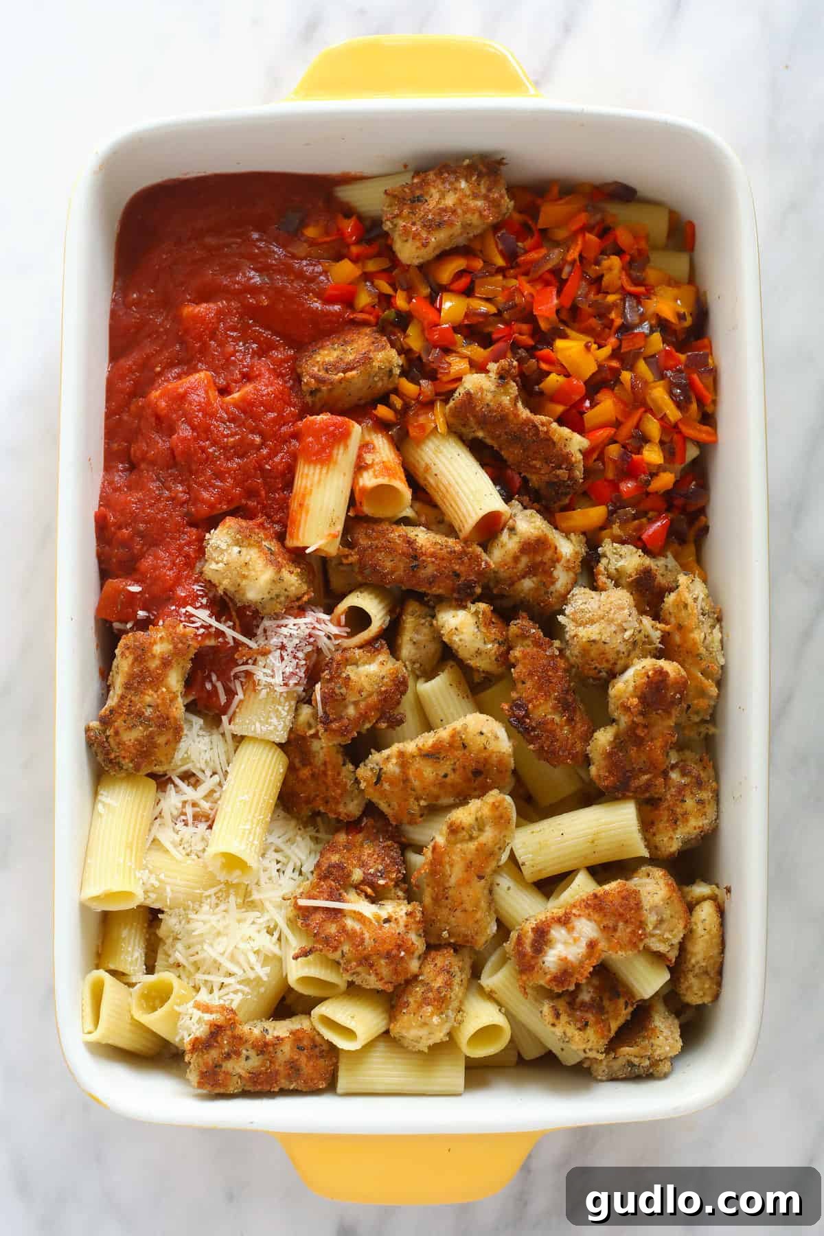 Ultimate Cheesy Chicken Parmesan Bake 4 All the ingredients for the chicken parmesan casserole in a casserole dish.