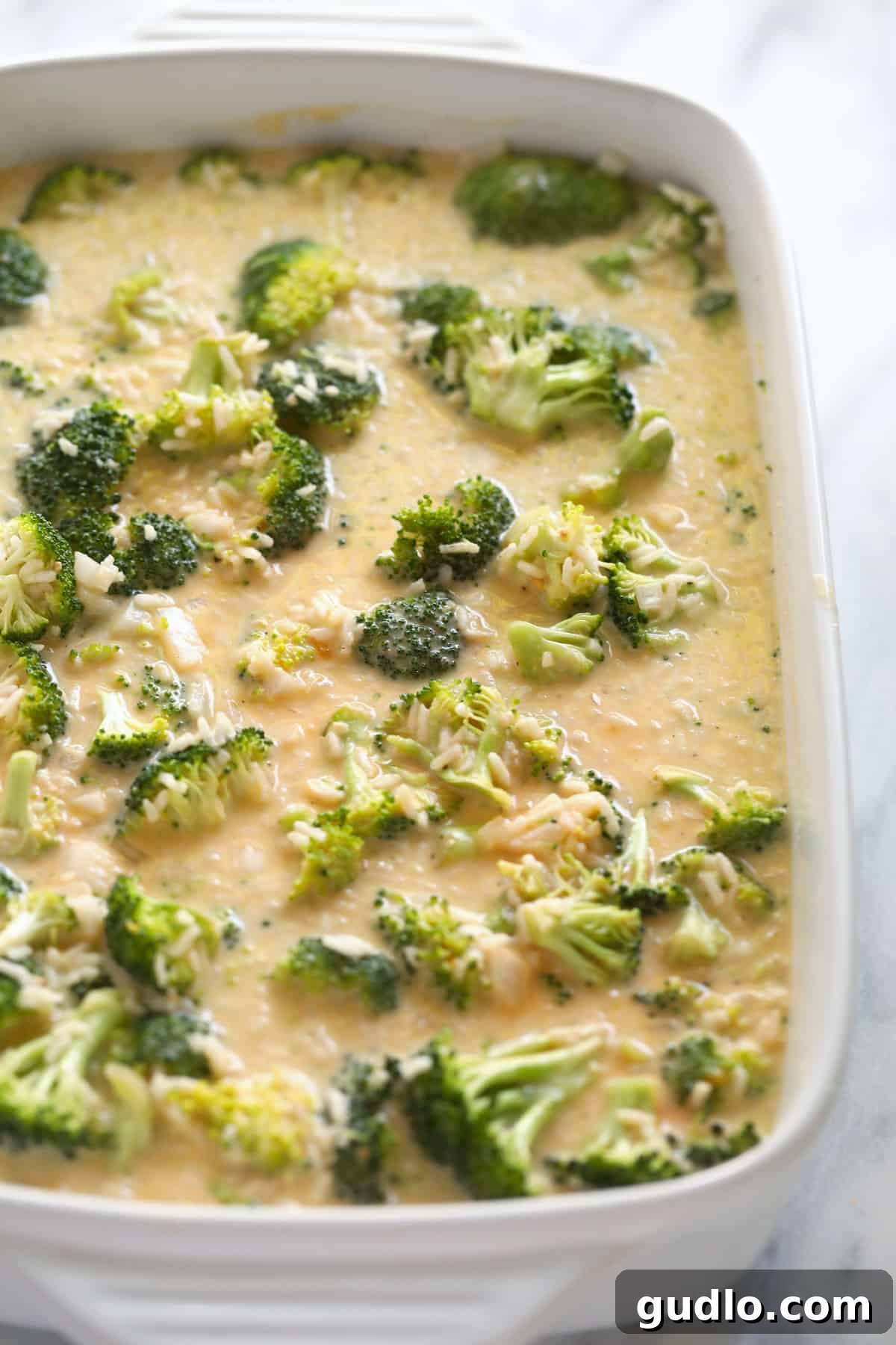Mixed broccoli and cheese ingredients in a casserole dish, ready for baking to achieve cheesy perfection.