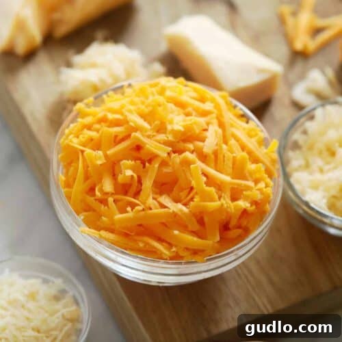 A block of cheese and various grated cheeses, illustrating different grating methods.