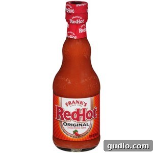 A vibrant red bottle of Frank's RedHot Original Hot Sauce, essential for imparting authentic buffalo flavor into these Nachos.