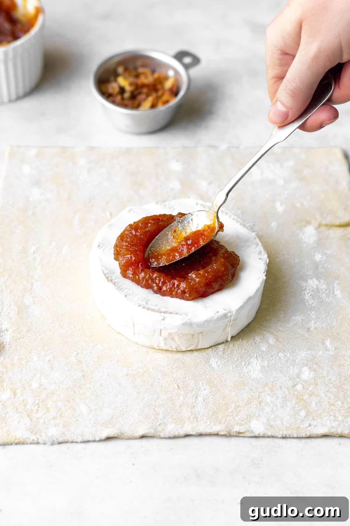 fig jam being spread generously on top of brie cheese.