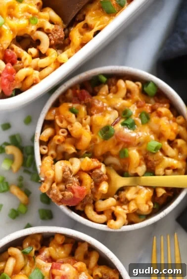 two bowls of macaroni and cheese casserole with a fork.