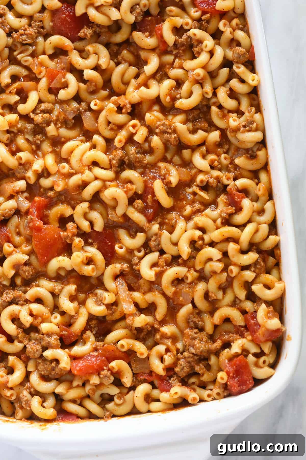 Noodles and tomato sauce in casserole dish.