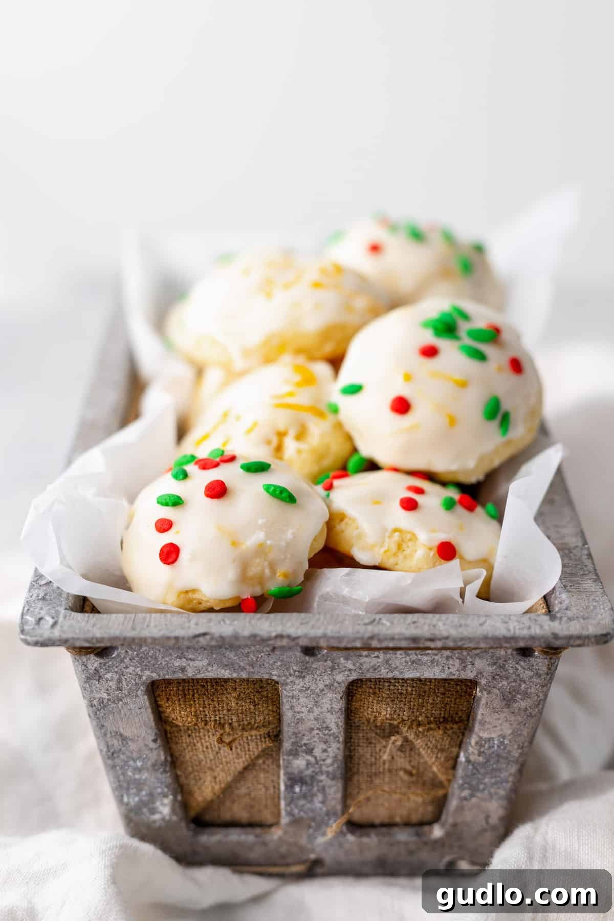 A basket overflowing with perfectly baked, glazed, and decorated ricotta cookies, showcasing their inviting texture and festive appearance.