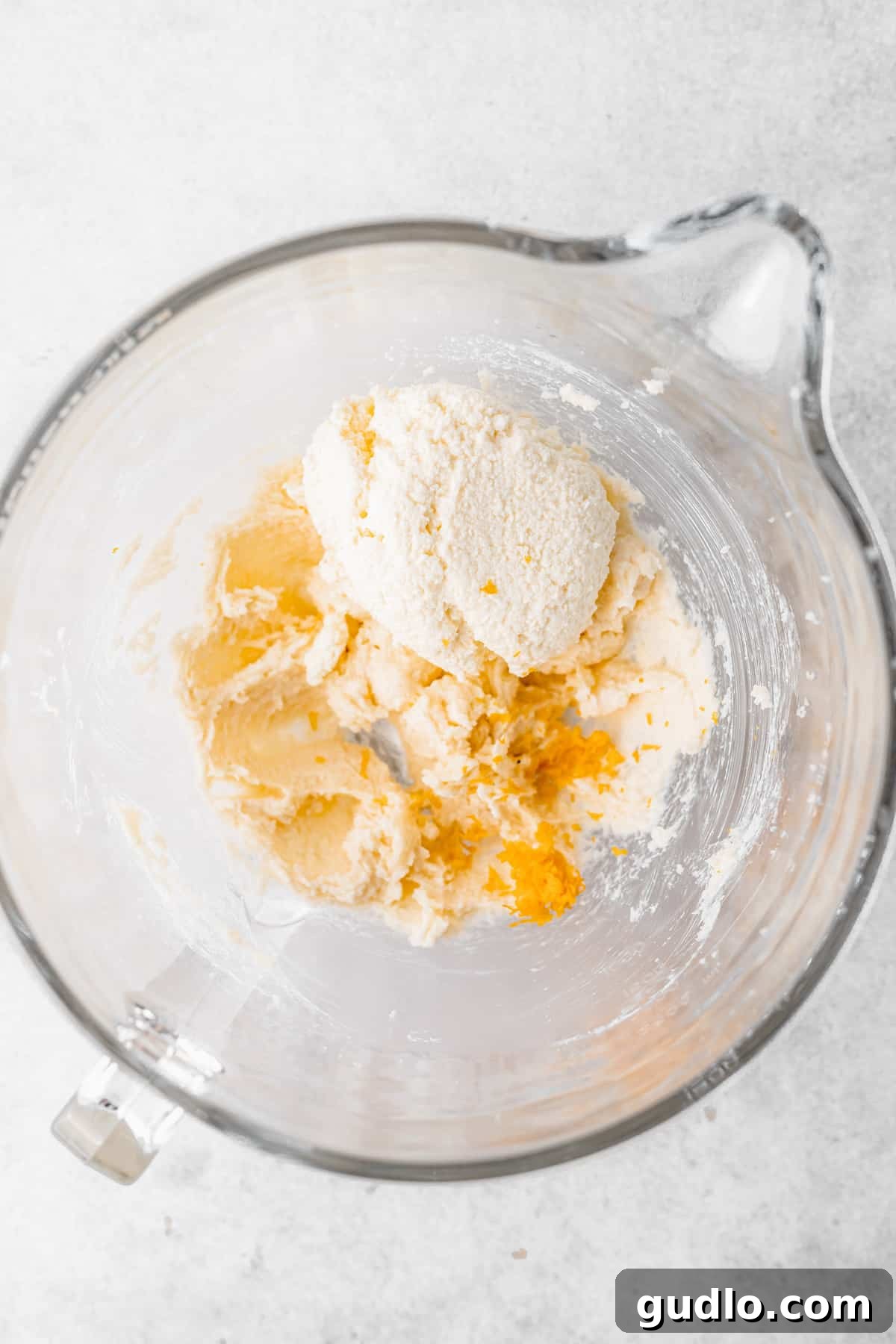 A bowl of creamy ricotta cookie dough, visibly softened, indicating it's ready for chilling.