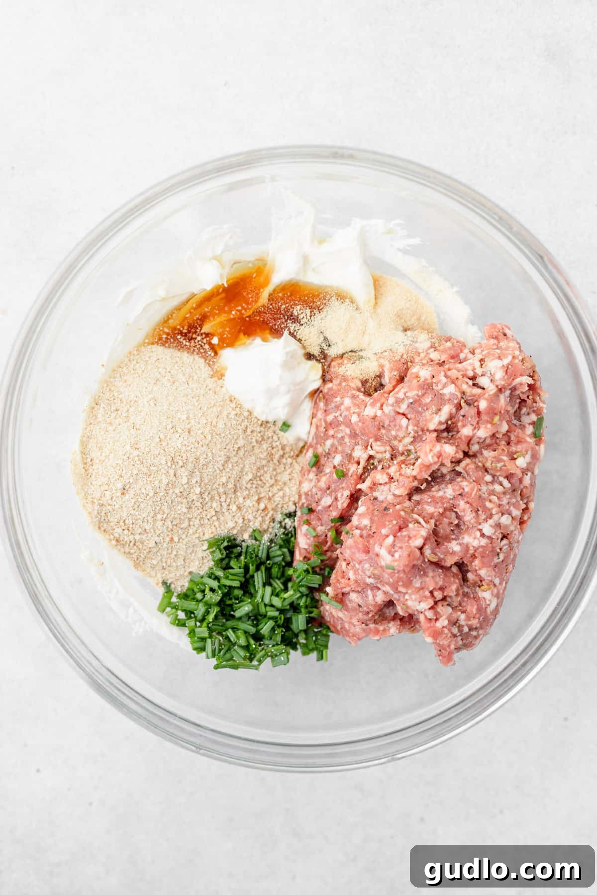 These Cream Cheese Sausage Balls make a fantastic appetizer for any occasion! Dip them in a perfectly zesty creamy garlic sauce, and enjoy! cream cheese sausage ball ingredients in a bowl, ready to be mixed