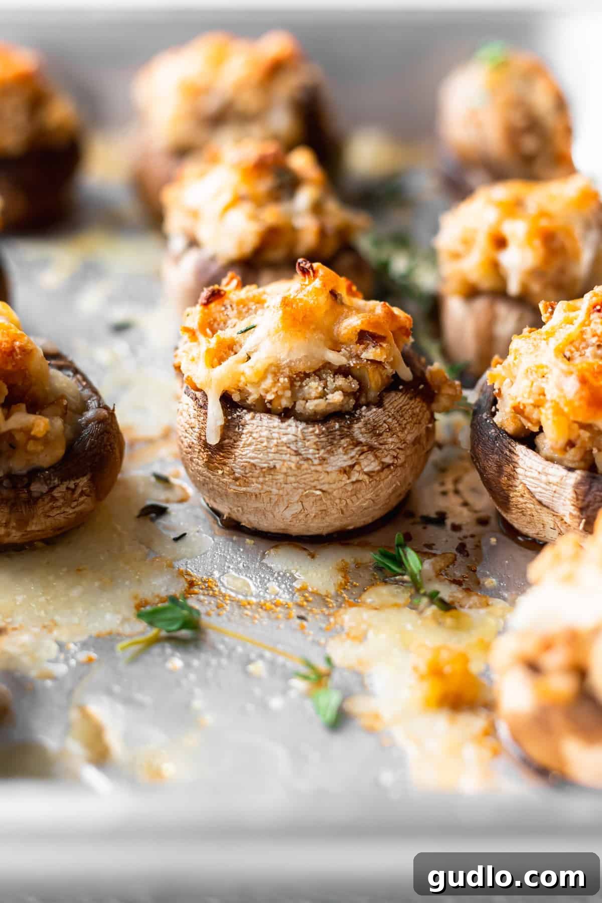 Golden brown cream cheese stuffed mushrooms artfully arranged on a baking tray, fresh from the oven and ready to serve.