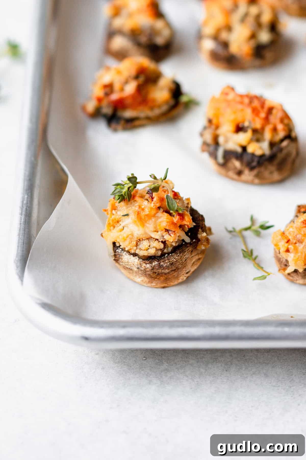 A freshly baked tray of golden brown cream cheese stuffed mushrooms, perfectly cooked and ready to be served as an appetizer.