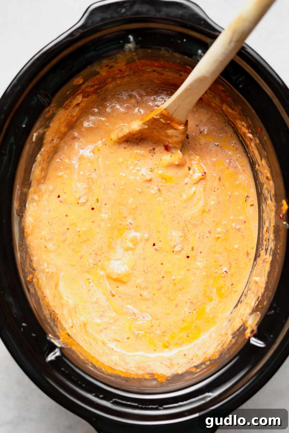 Delicious Slow Cooker Queso Dip Ready A slow cooker brimming with perfectly melted, golden-brown queso dip, ready to be served.