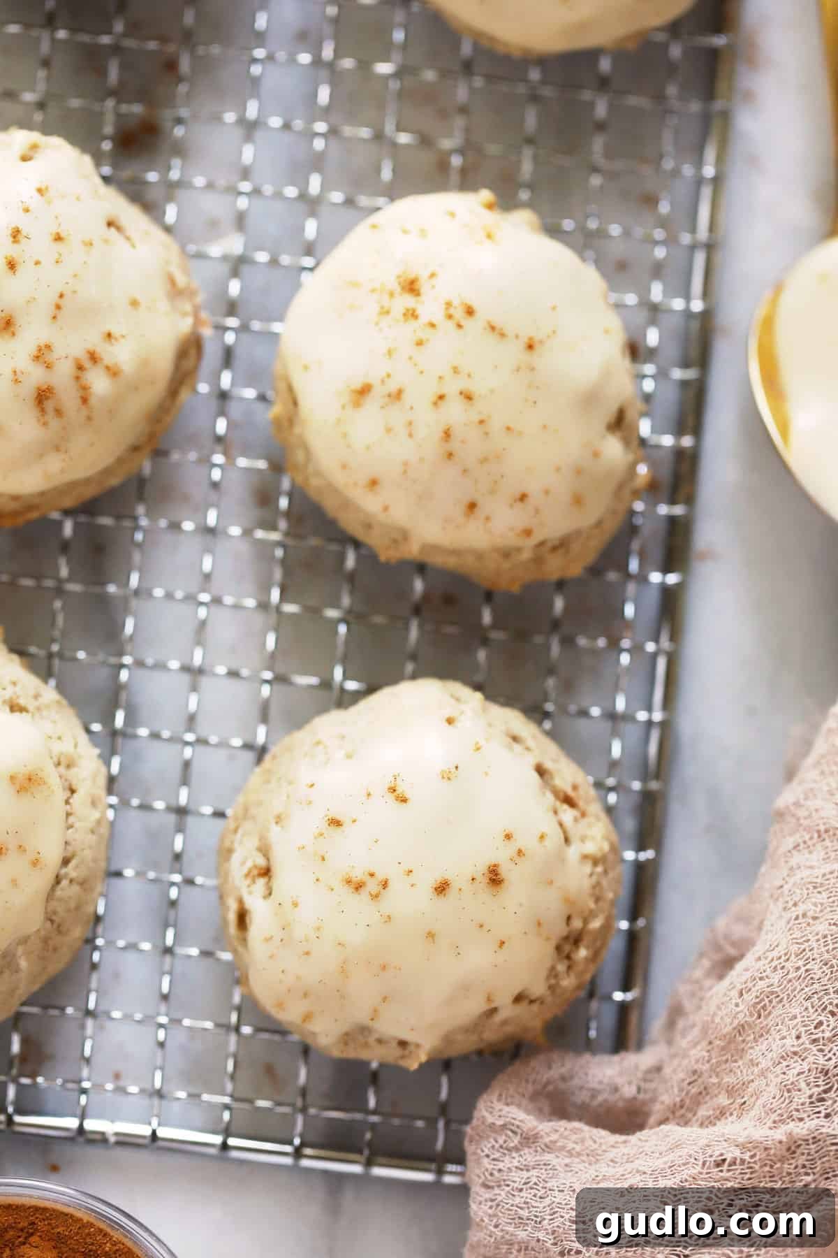 Perfectly baked pumpkin spice cream cheese cookies arranged on a cooling rack, glistening with maple glaze.