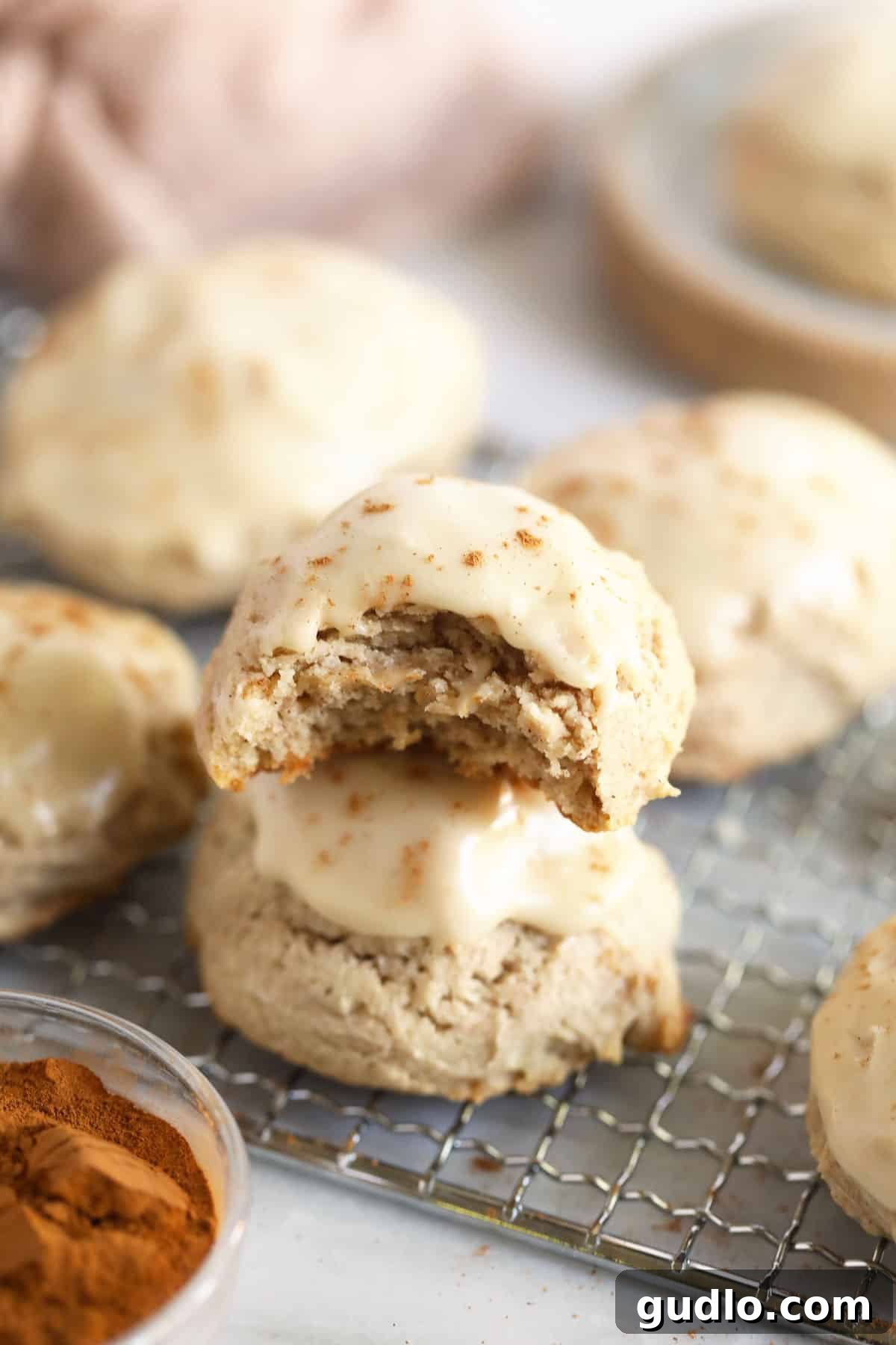 Close-up of a glazed pumpkin spice cream cheese cookie on a cooling rack, showing its soft texture.