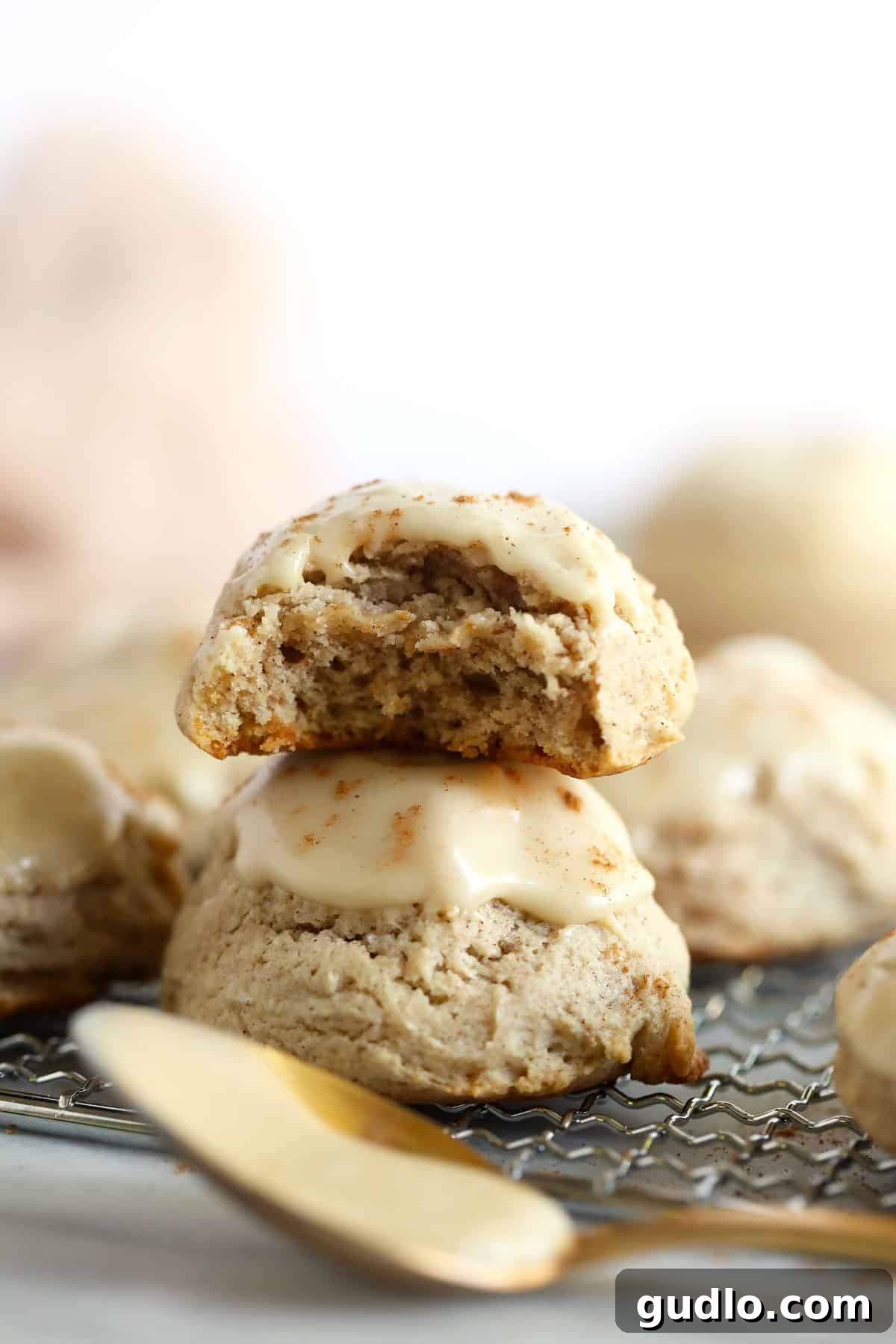 Two pumpkin spice cream cheese cookies stacked, showcasing their moist interior and thick maple glaze.