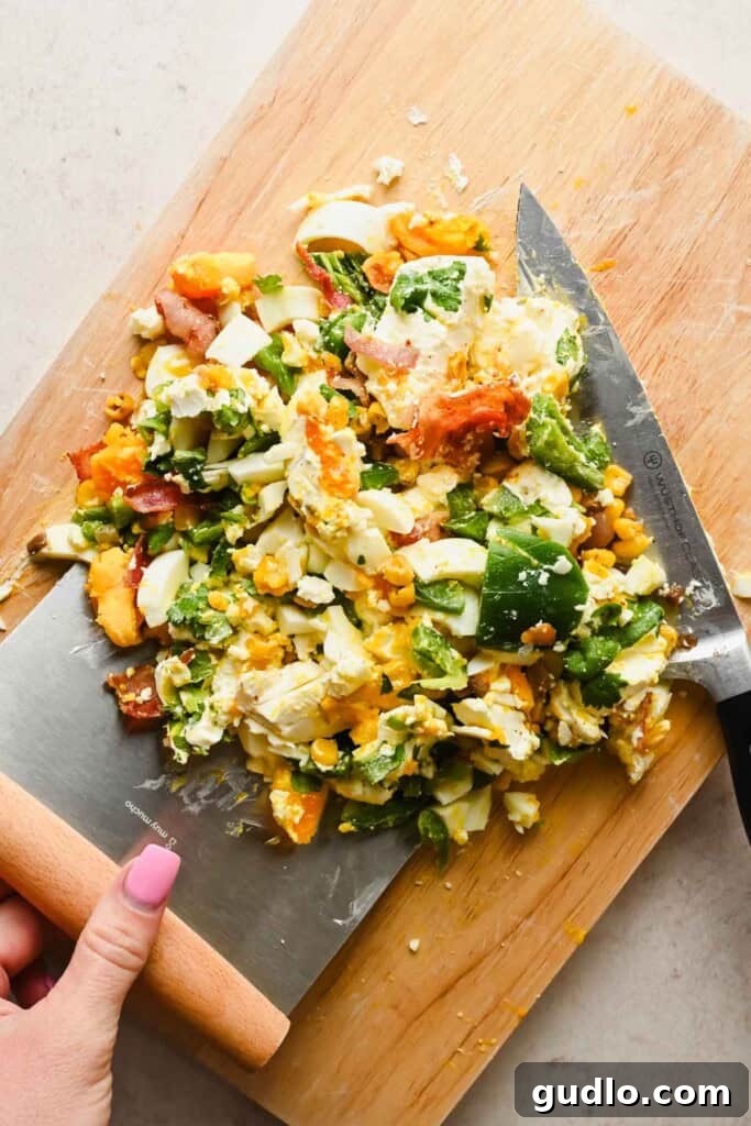 The street corn bagel mixture halfway through the chopping process, showing the ingredients starting to combine.