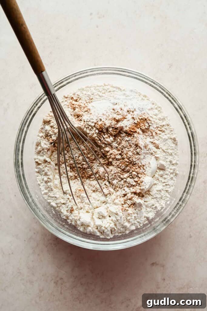 Morning Buzz Banana Cake 4 Preparing the dry ingredients for the banana coffee cake by whisking flour and spices in a glass bowl.