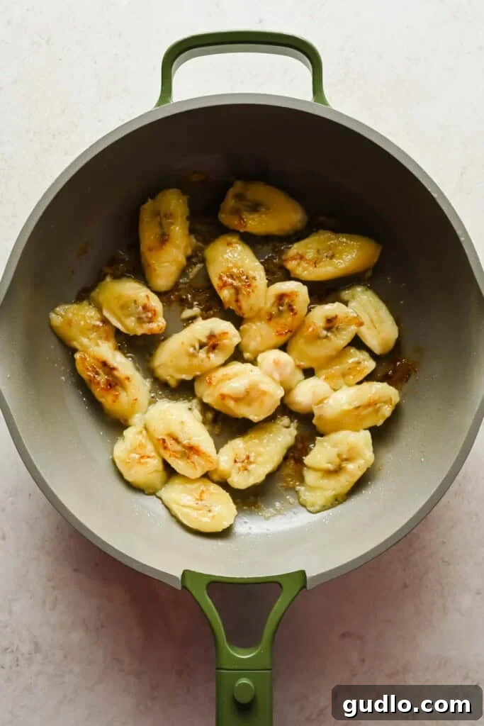 Morning Buzz Banana Cake 7 Sautéing sliced bananas in a pan to caramelize their sugars before adding to the cake batter.