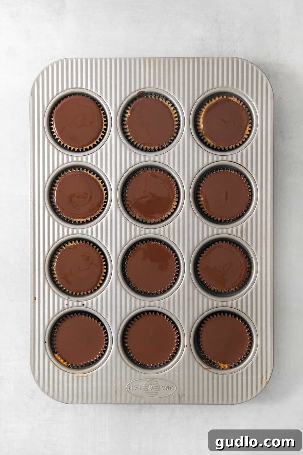 Mini Espresso Cheesecake Cups: No-Bake Coffee Dessert 4 Mini espresso cheesecake cups with chocolate topping arranged on a white surface.