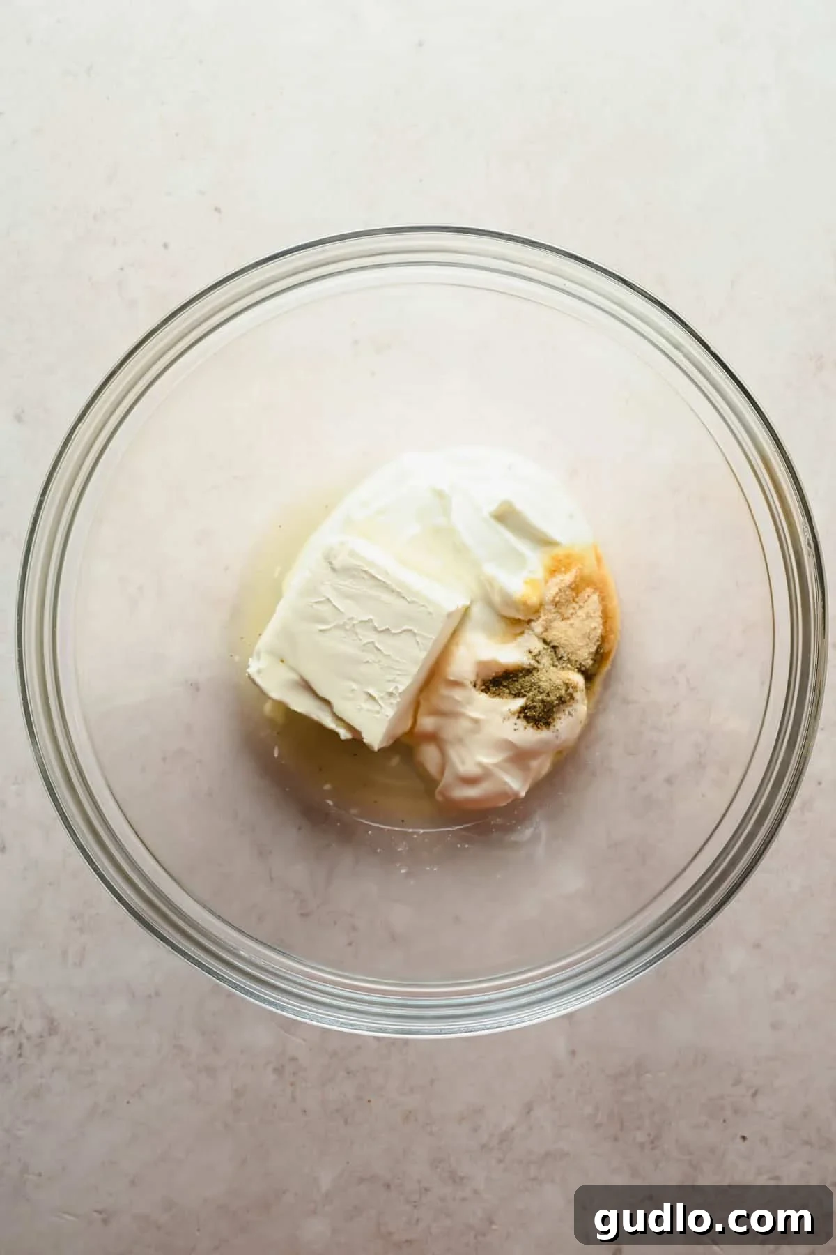 Cream cheese, mayo, Greek yogurt, lemon juice, and seasonings in a glass bowl for dressing