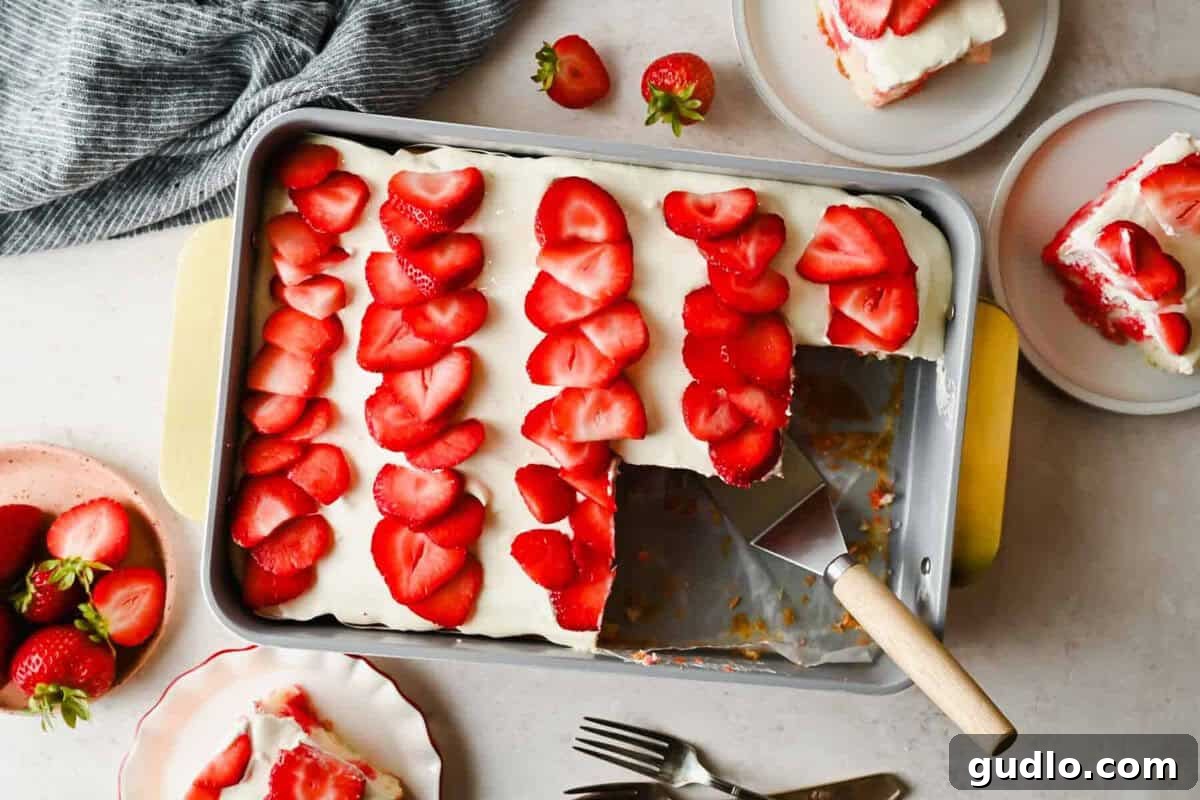 Moist Strawberry Poke Cake with Cream Cheese Frosting 2 Rectangular cake in a pan topped with rows of sliced strawberries and white frosting, with one piece served on a plate; strawberries and utensils nearby.