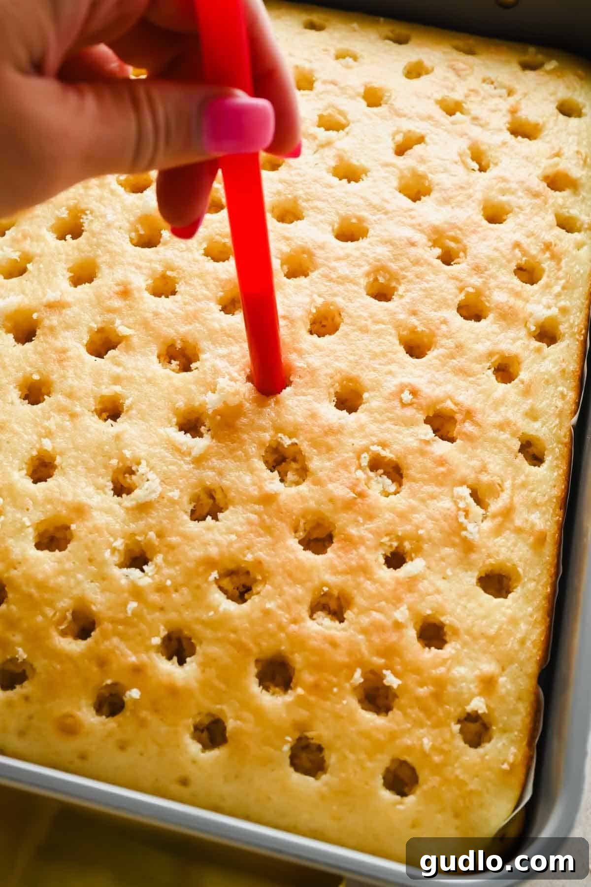 Moist Strawberry Poke Cake with Cream Cheese Frosting 3 Using a straw to poke evenly spaced holes into a baked vanilla cake