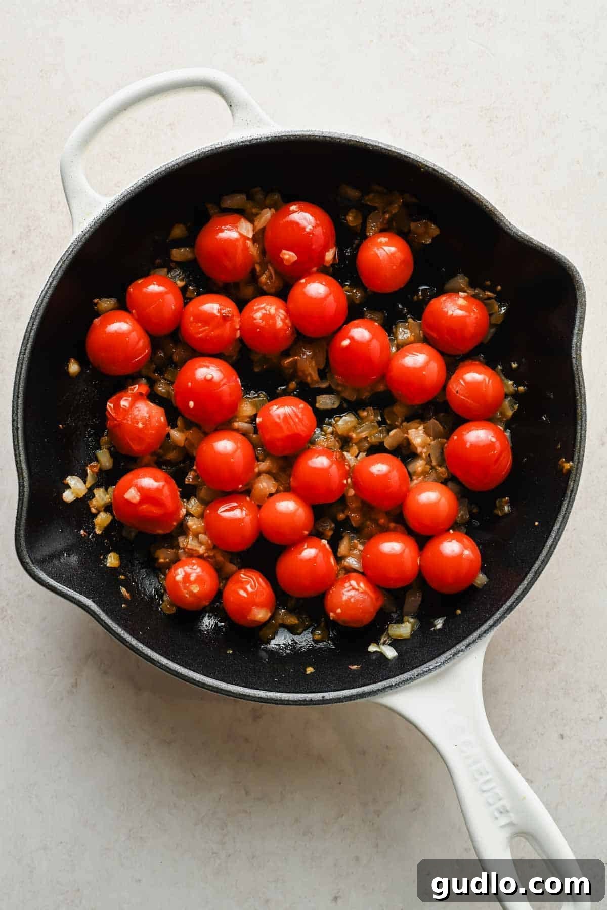 Creamy Spicy Cottage Cheese Pasta with Tomatoes and Peas 3 Burst cherry tomatoes, onions, and garlic in a skillet