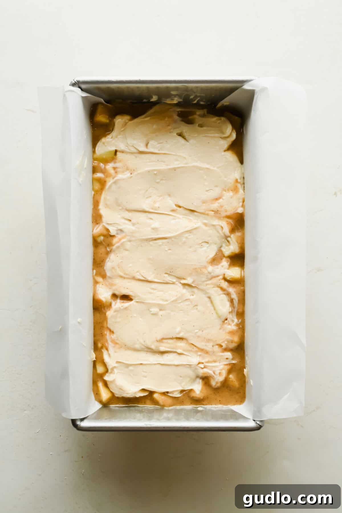 Apple Fritter Bread with Cream Cheese Swirl 6 Cream cheese filling spread over apple bread batter in a loaf pan